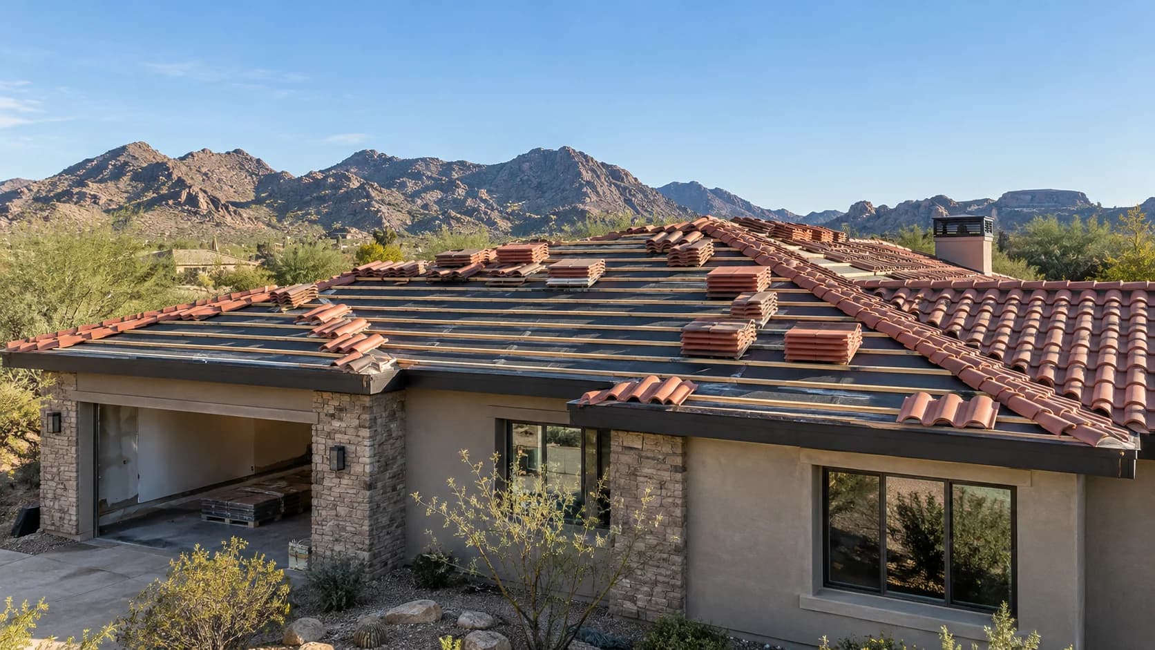 Clay tile roofing installation underway on a single-story desert house